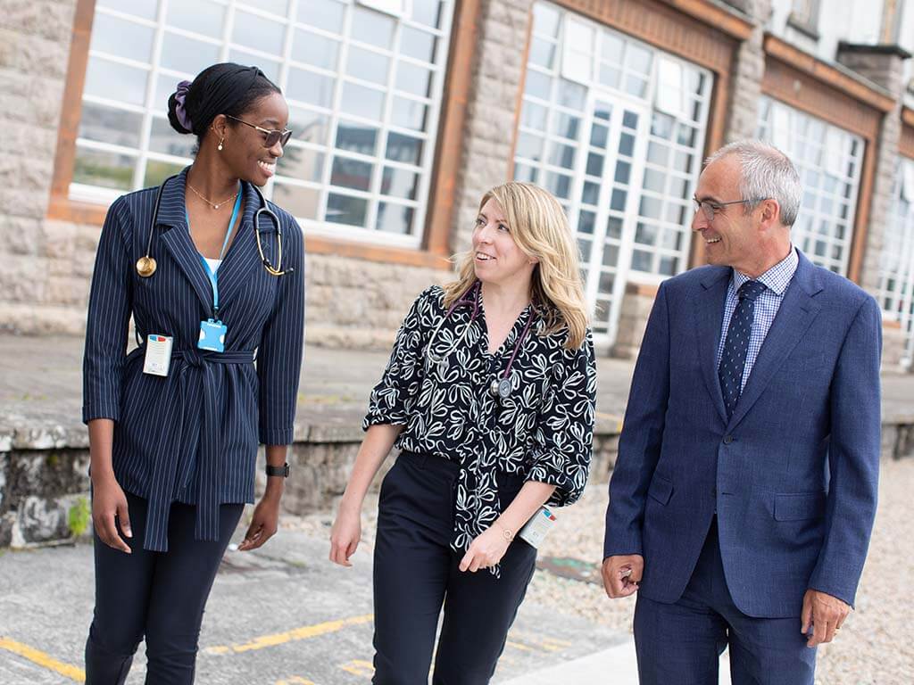 Senior doctors walking on hospital grounds at University Hospital Galway